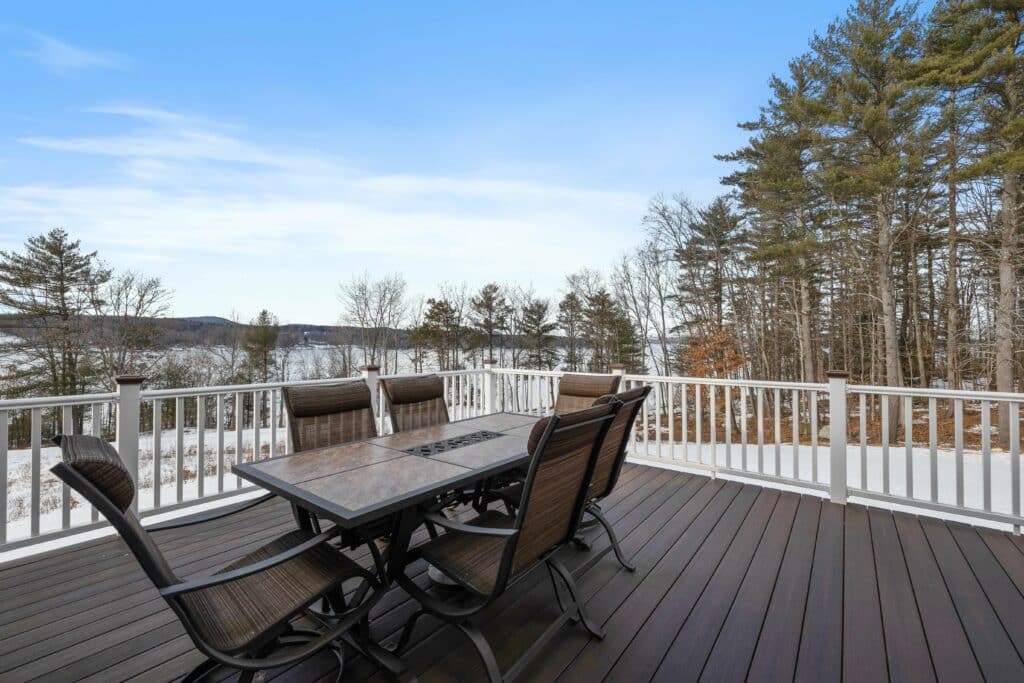 An outdoor patio dining set on a wooden terrace under a blue and clear sky