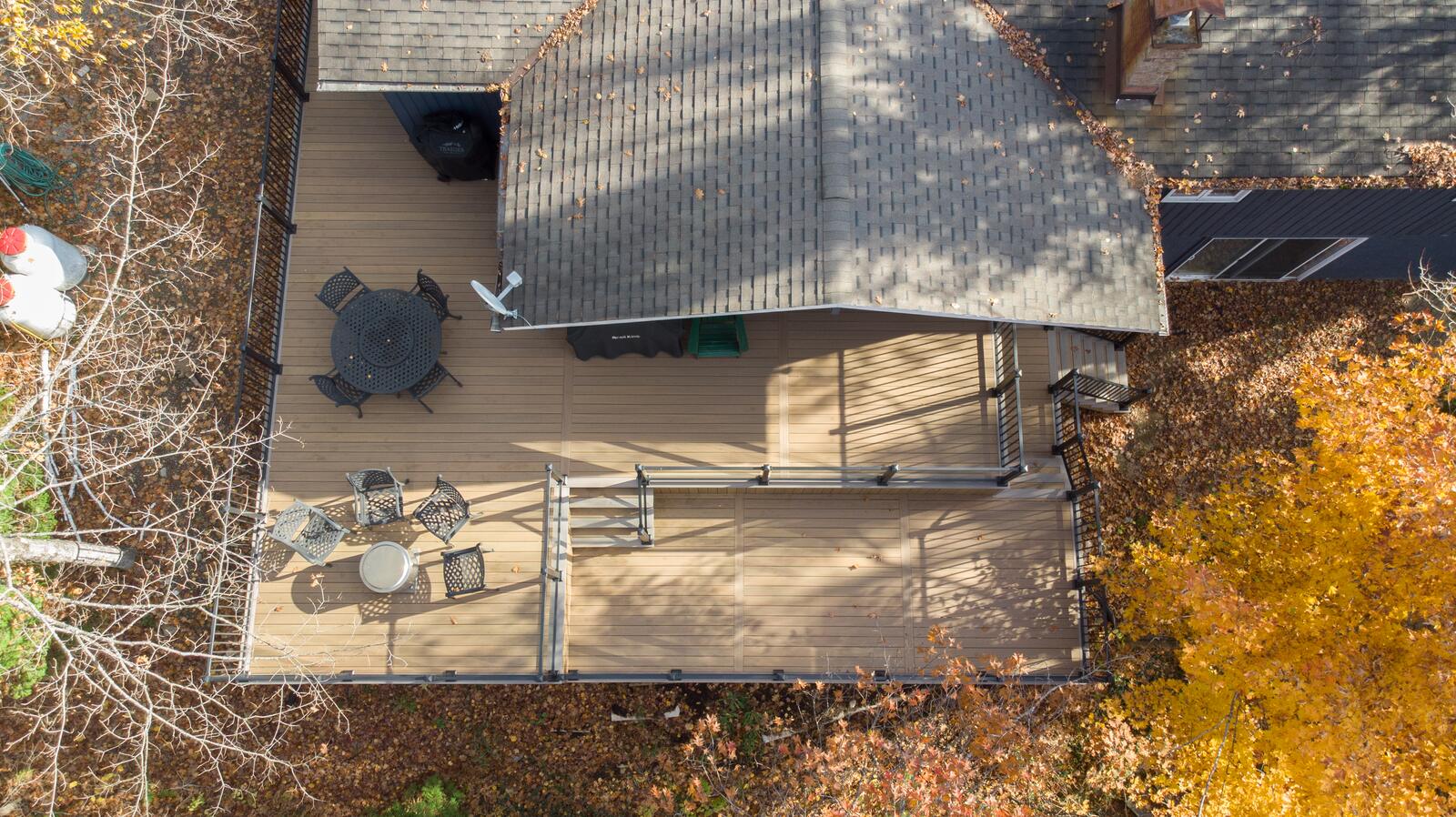 Aerial view of a wraparound deck with dining areas in fall colours, Muskoka