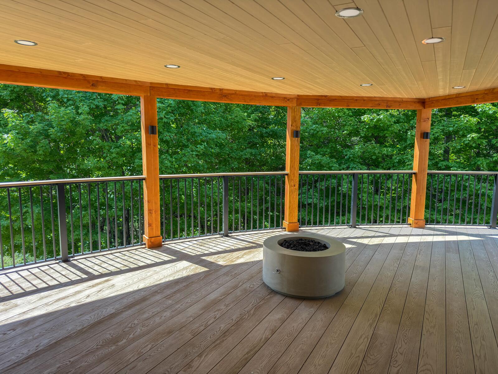Covered deck with cedar ceiling, timber posts and a fire bowl in Muskoka