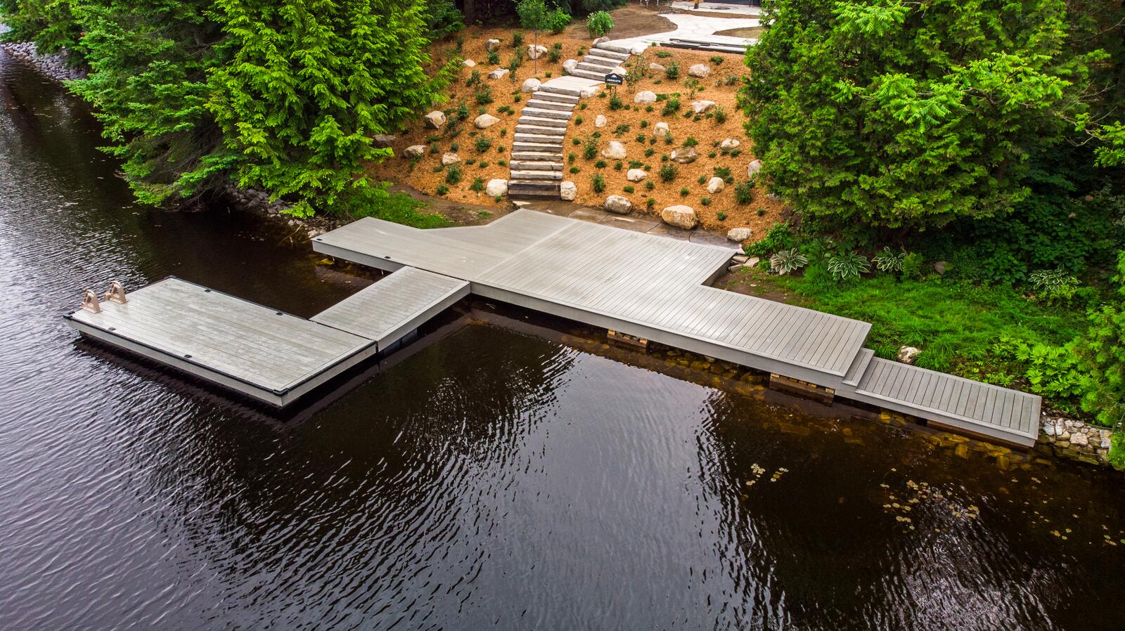Aerial view of a custom dock and landscaped granite shoreline in Muskoka